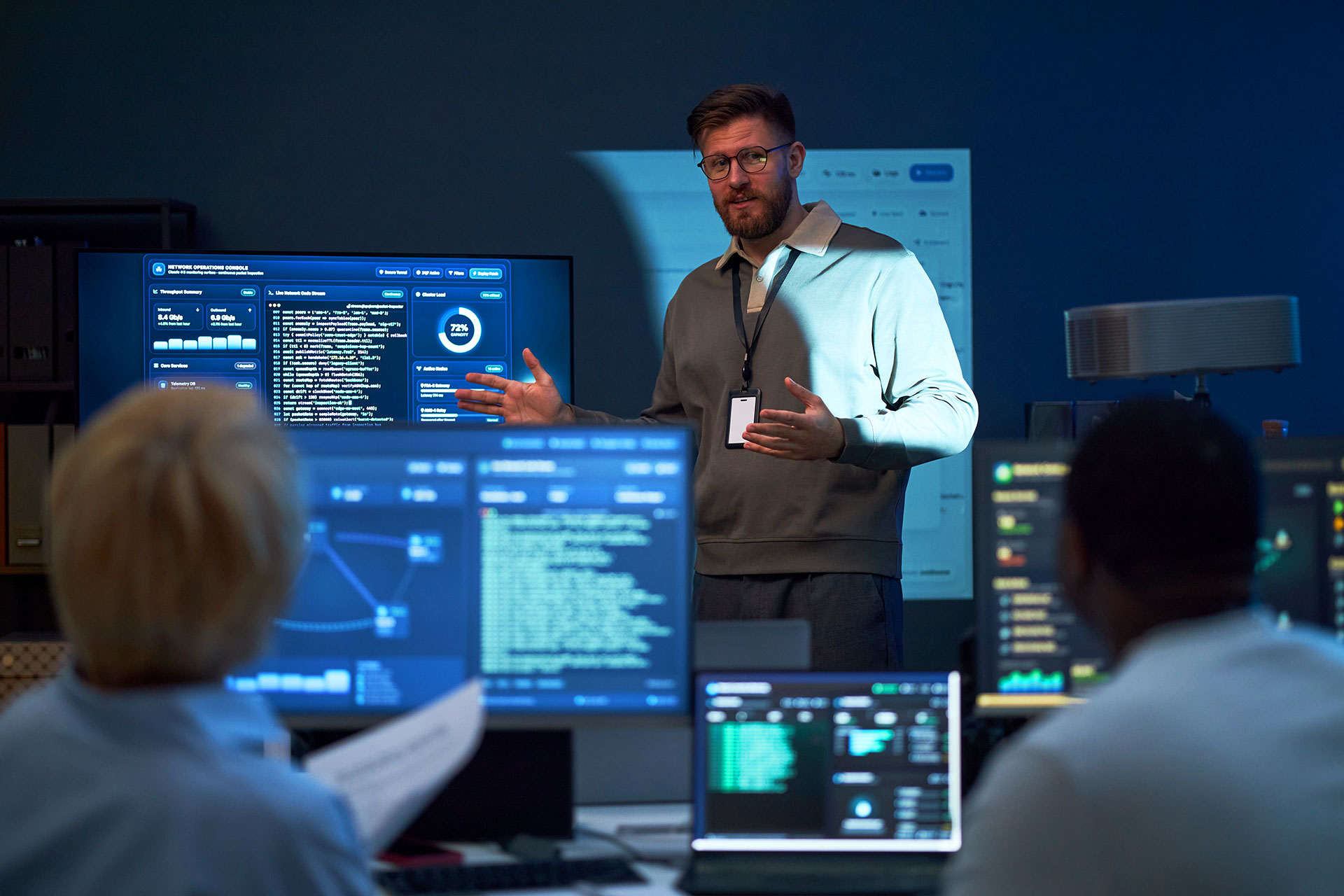 IT specialist presenting network operations dashboard to seated team